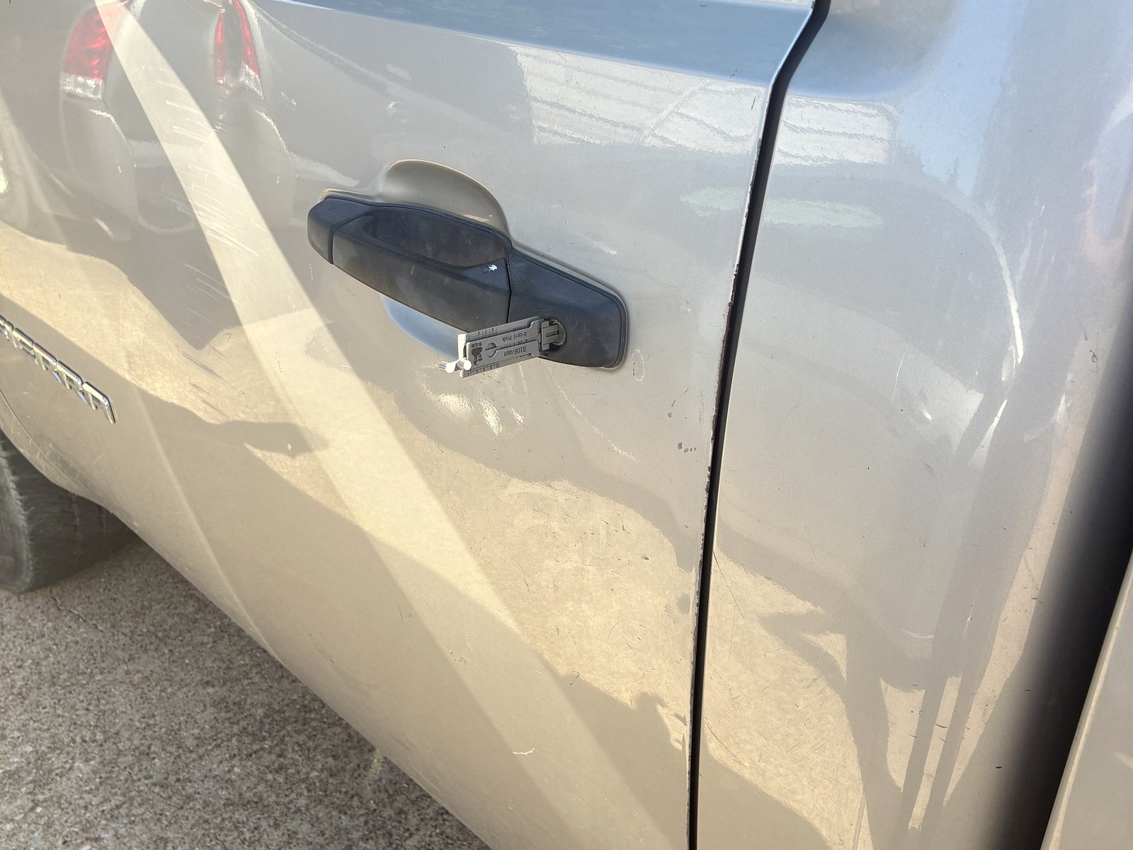 GMC truck door being unlocked with a Lishi tool during a car lockout